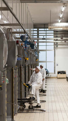 Хора работят във фабрика Hero в Испания с енергоспестяващо светодиодно осветление от Philips