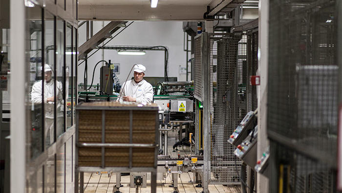 Служител работи във фабрика Hero с енергоспестяващо светодиодно осветление от Philips за хранително-вкусовата промишленост