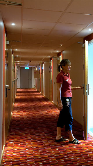 Жена в коридора на хотел Спар с хотелско осветление от Philips