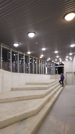  Човек се изкачва по стълбите в паркинга Ейтерен с осветление от Philips 