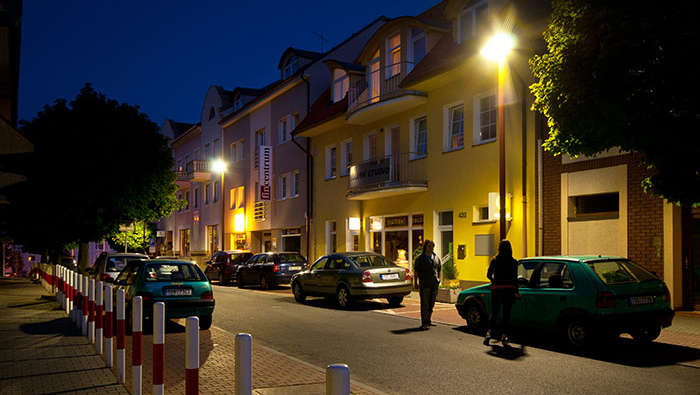 Хора се разхождат по улицата нощем с улично осветление от Philips 