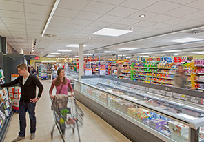 Двойка върви по пътеката в супермаркет с енергийно ефективно осветление от Philips 