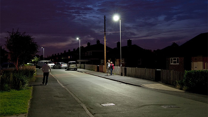 Хора ходят по улица, осветена от Philips